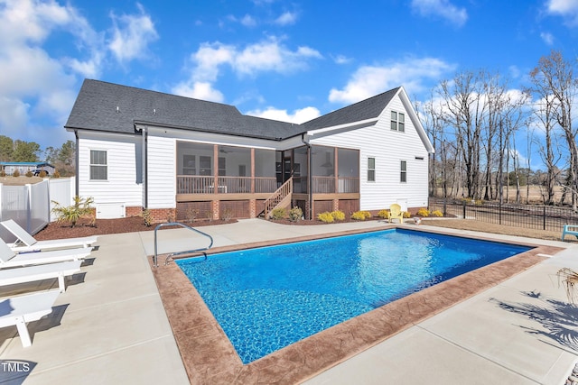 view of swimming pool featuring a patio, a fenced backyard, a sunroom, and a fenced in pool