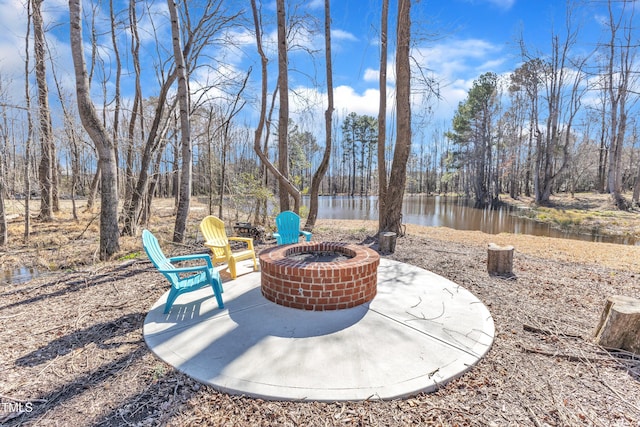 view of patio with a water view and an outdoor fire pit