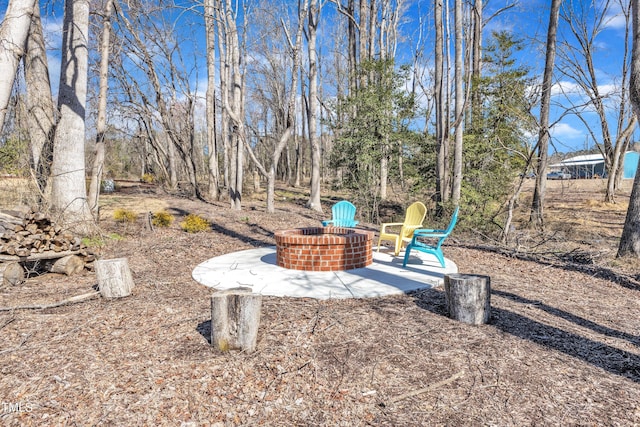 view of yard featuring a fire pit and a patio