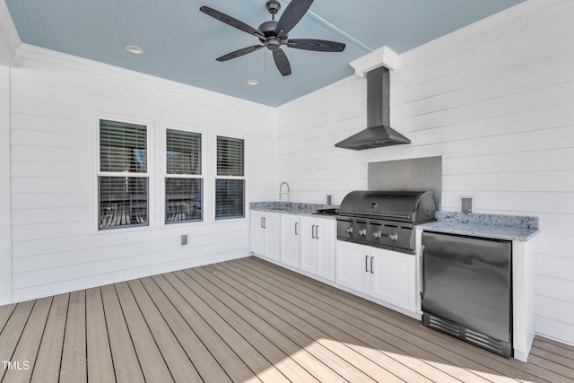 wooden deck with area for grilling, ceiling fan, an outdoor kitchen, and a sink