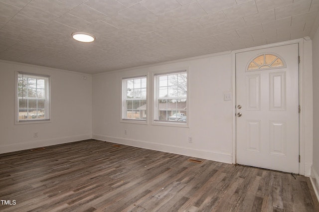 entrance foyer featuring dark wood-type flooring and ornamental molding