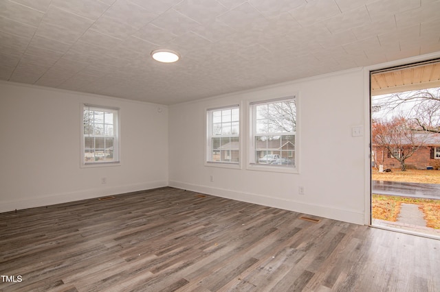 unfurnished room featuring ornamental molding, hardwood / wood-style floors, and a wealth of natural light