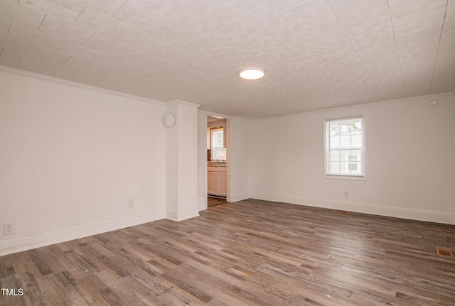 spare room with crown molding and hardwood / wood-style floors