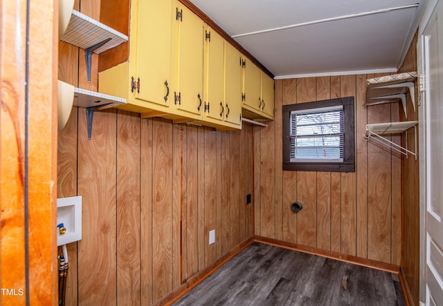 clothes washing area featuring cabinets, washer hookup, dark hardwood / wood-style flooring, and wood walls