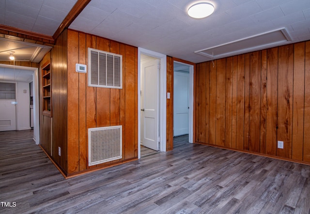 interior space with wood walls, built in features, and light wood-type flooring