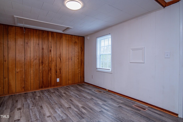 unfurnished room featuring wood walls and light hardwood / wood-style flooring