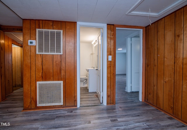 hallway featuring hardwood / wood-style floors and wooden walls