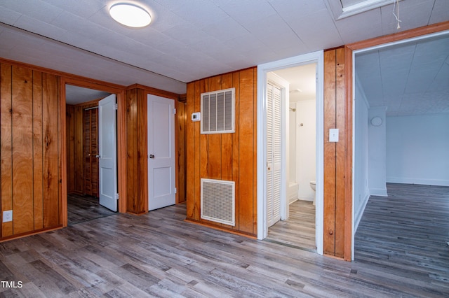 spare room with hardwood / wood-style flooring and wood walls