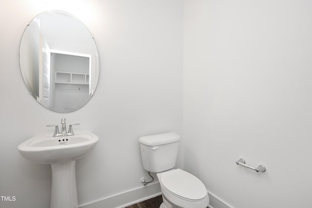 bathroom featuring hardwood / wood-style flooring and toilet