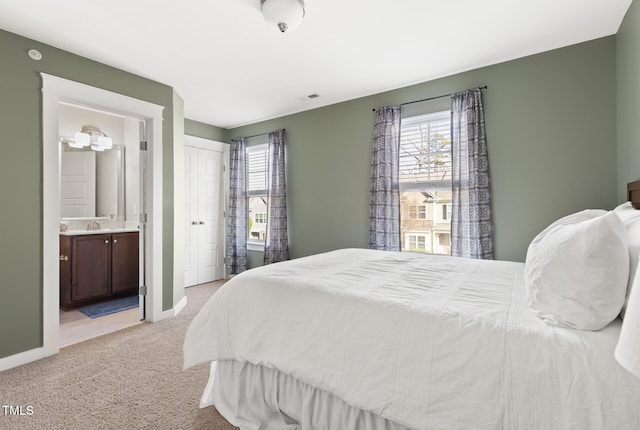 carpeted bedroom featuring connected bathroom and a closet