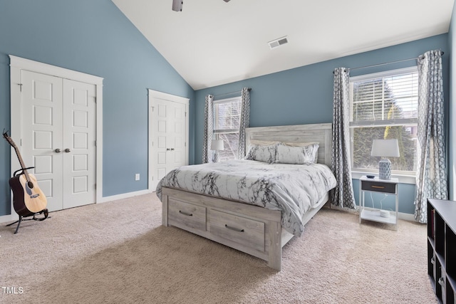 bedroom with ceiling fan, high vaulted ceiling, light carpet, and multiple windows