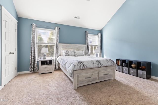 bedroom with lofted ceiling and light colored carpet