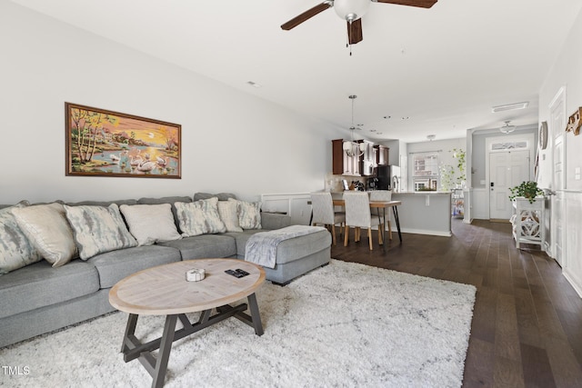 living room with ceiling fan and dark hardwood / wood-style flooring