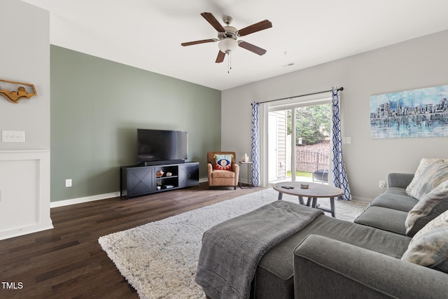 living room featuring dark wood-type flooring and ceiling fan