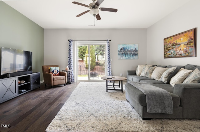 living room featuring dark wood-type flooring and ceiling fan