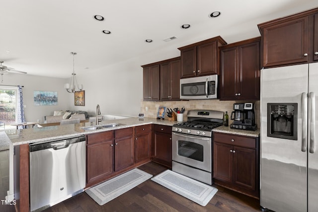 kitchen featuring sink, dark hardwood / wood-style flooring, decorative backsplash, kitchen peninsula, and stainless steel appliances