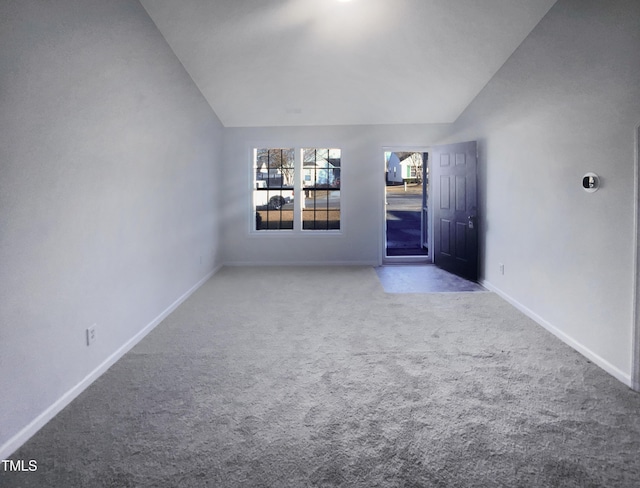 carpeted empty room featuring lofted ceiling