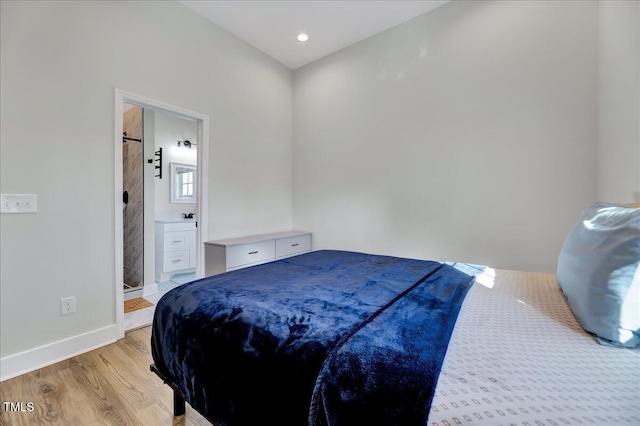 bedroom featuring a barn door, connected bathroom, recessed lighting, baseboards, and light wood finished floors