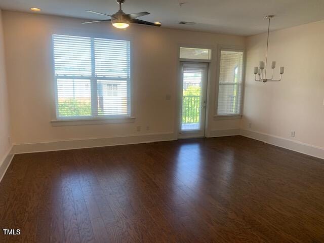 unfurnished room featuring a healthy amount of sunlight, dark wood finished floors, and baseboards