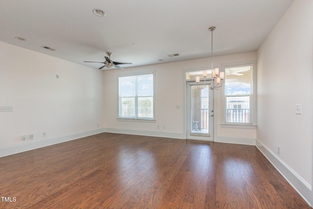 spare room featuring visible vents, baseboards, dark wood finished floors, and ceiling fan with notable chandelier