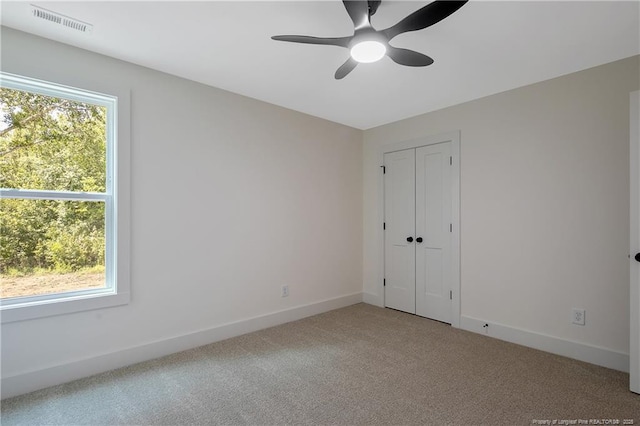 empty room with ceiling fan and carpet flooring