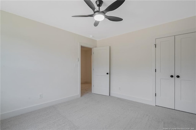 unfurnished bedroom with light colored carpet, ceiling fan, and a closet