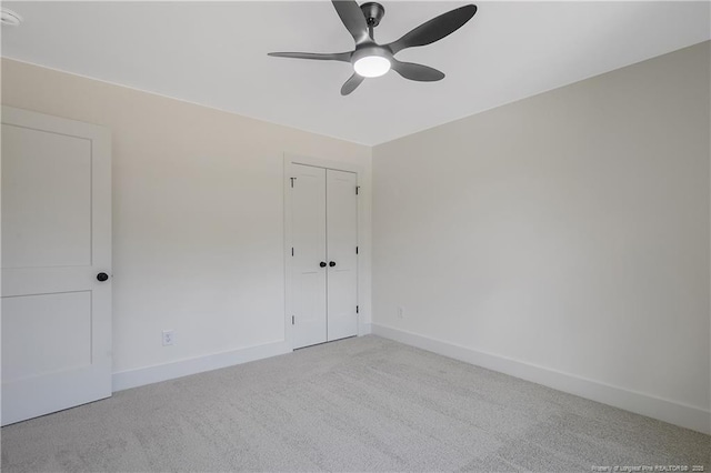 spare room featuring light carpet and ceiling fan