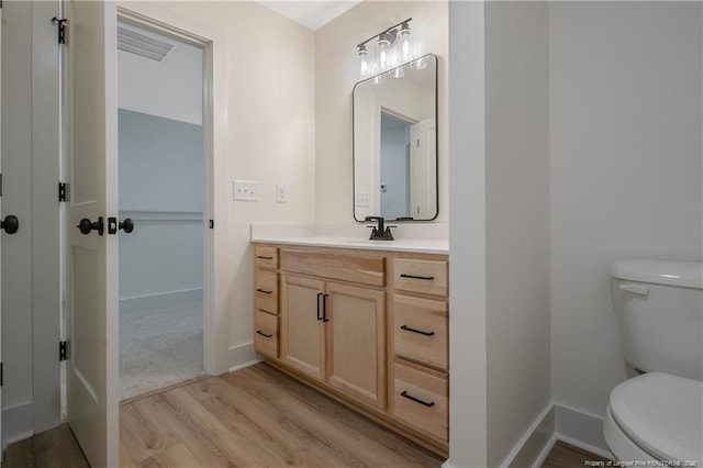 bathroom with vanity, toilet, and hardwood / wood-style floors