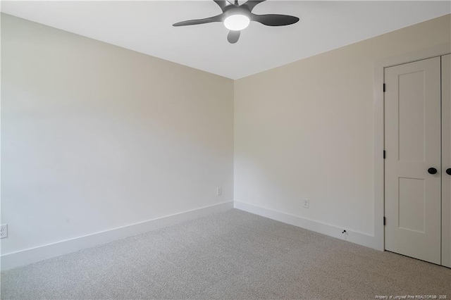 carpeted spare room featuring ceiling fan