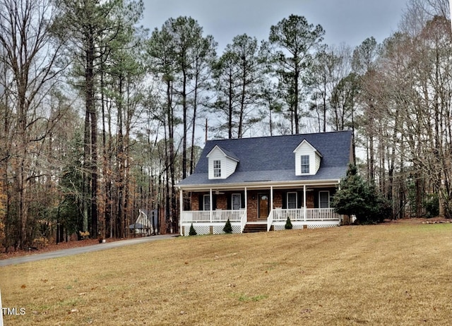 cape cod house featuring covered porch and a front yard