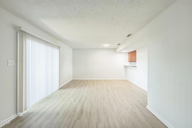 408 Cumbrian Ct, Fayetteville, NC 28314 - unfurnished living room featuring light wood finished floors, a textured ceiling, and baseboards
