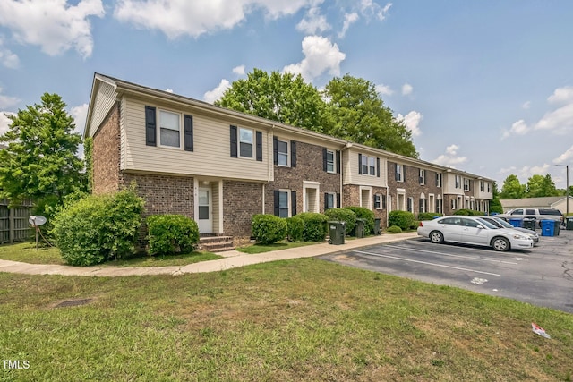 408 Cumbrian Ct, Fayetteville, NC 28314 - multi unit property with uncovered parking, a front yard, brick siding, and a residential view
