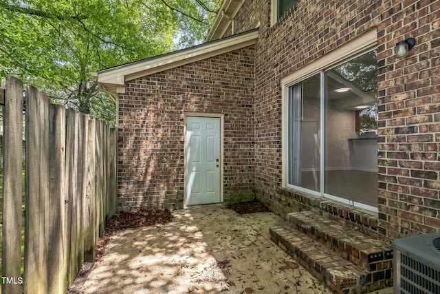 408 Cumbrian Ct, Fayetteville, NC 28314 - property entrance featuring brick siding, fence, a patio area, and cooling unit