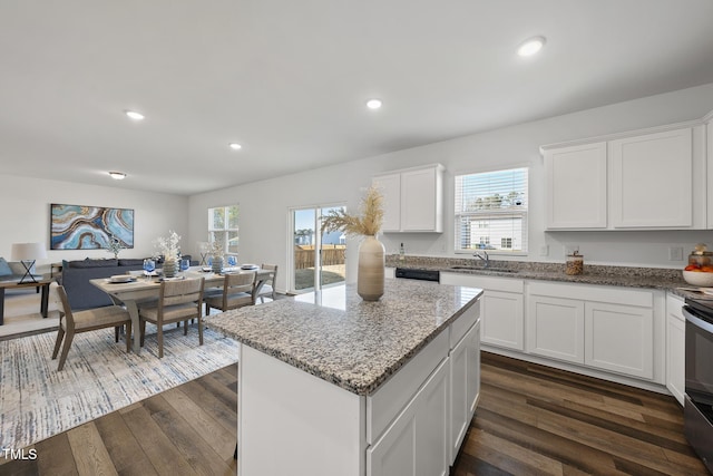 kitchen featuring light stone counters, recessed lighting, dark wood-type flooring, white cabinets, and a center island