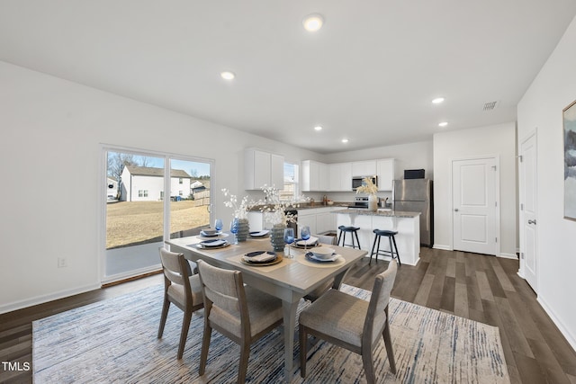 dining room featuring baseboards, visible vents, dark wood finished floors, and recessed lighting