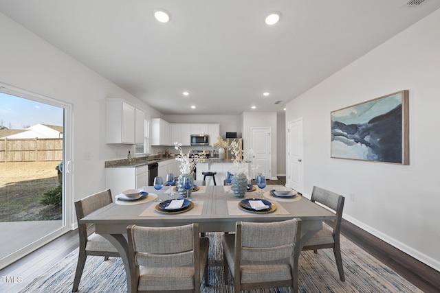 dining room featuring baseboards, wood finished floors, and recessed lighting