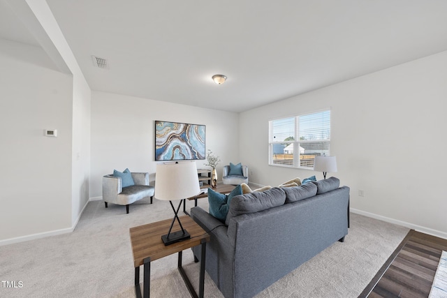 living area featuring carpet flooring, visible vents, and baseboards