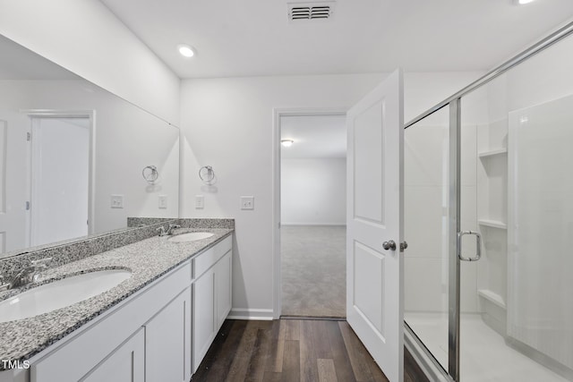 full bathroom with a shower stall, visible vents, a sink, and wood finished floors