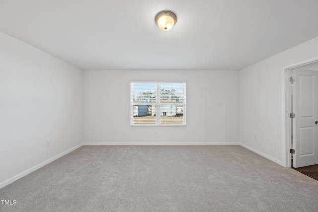 carpeted spare room with baseboards