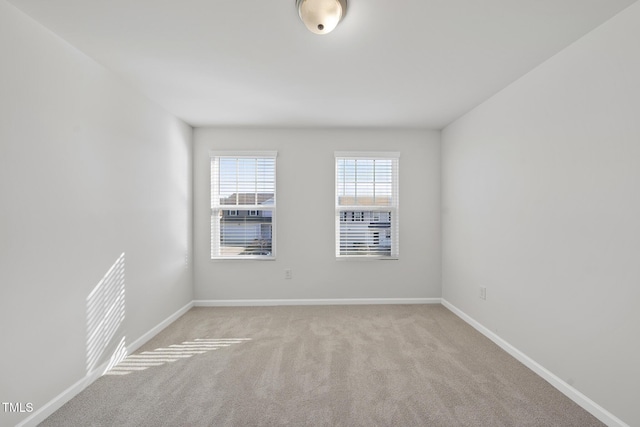 empty room with baseboards and light colored carpet