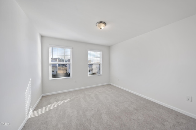 carpeted spare room with baseboards