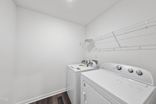 laundry area featuring laundry area, dark wood finished floors, washer and clothes dryer, and baseboards