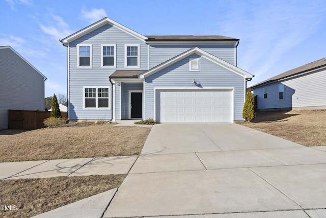 traditional home featuring a garage, fence, and concrete driveway