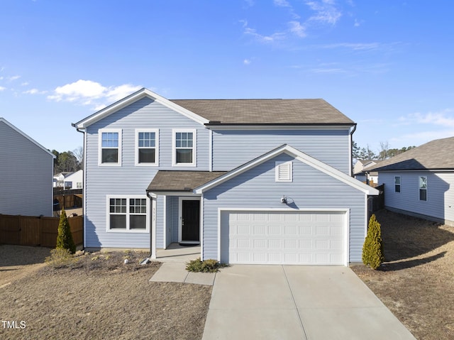 traditional-style home with fence, driveway, and an attached garage