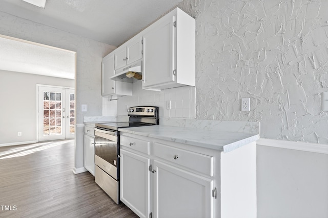 kitchen featuring decorative backsplash, white cabinetry, stainless steel range with electric cooktop, wood finished floors, and under cabinet range hood