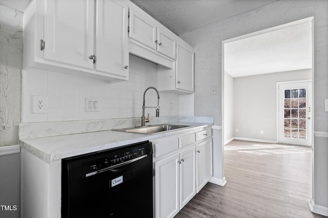 kitchen with dishwasher, wood finished floors, a sink, and white cabinetry