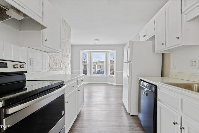 kitchen with white cabinets, dishwasher, under cabinet range hood, and stainless steel electric stove