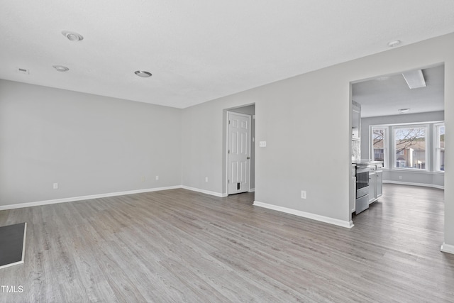 unfurnished living room with baseboards and wood finished floors