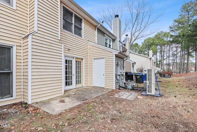 rear view of property with a patio area and a chimney