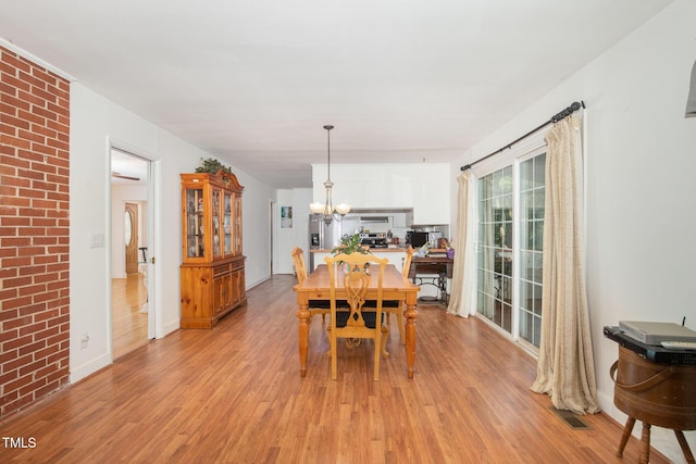 dining area featuring a notable chandelier and light wood-style floors